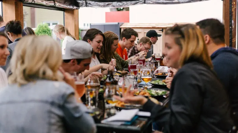 Des clients prennent leur repas dans une salle de restaurant pleine de monde