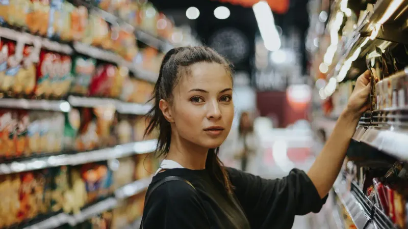 Femme selectionnant des aliments dans les rayons d’une boutique d’alimentation