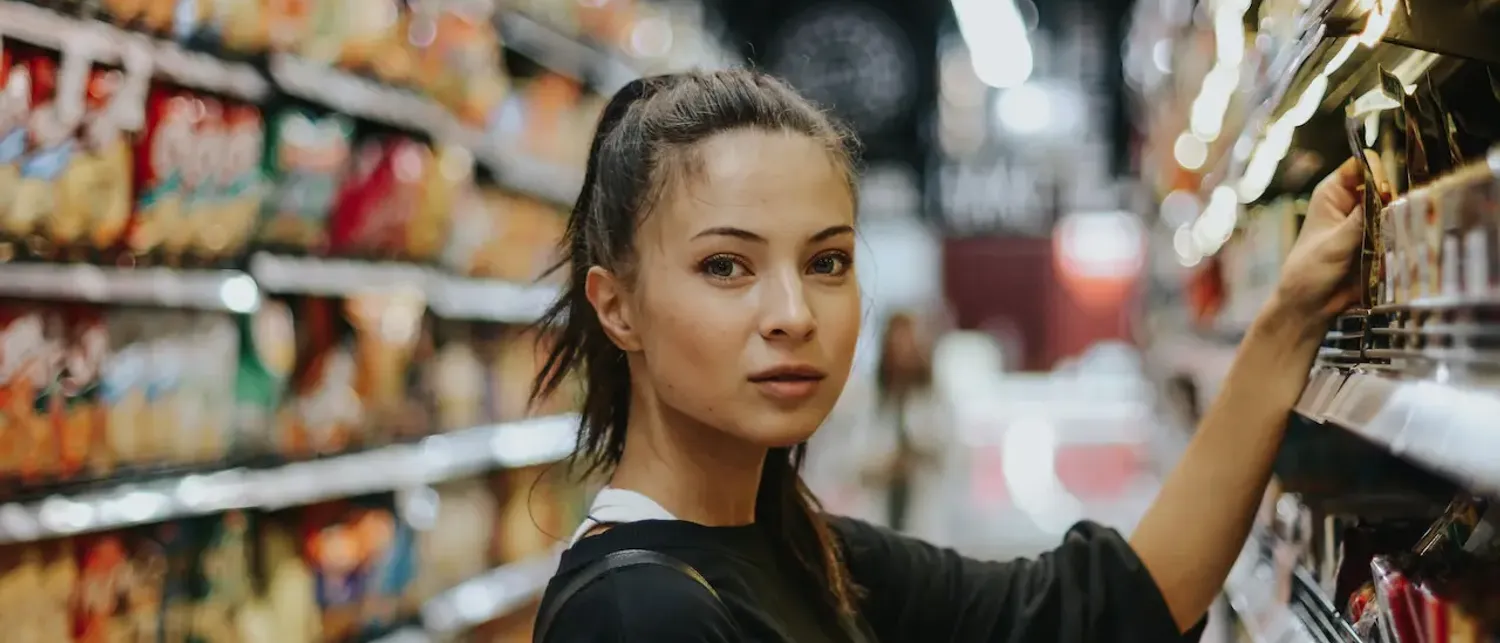 Femme selectionnant des aliments dans les rayons d’une boutique d’alimentation